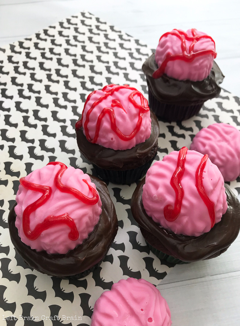 Bake these spooky Brain Halloween Cupcakes for your next Halloween party or zombie gathering. They're deliciously chocolate and easy to make with your favorite cake recipe or boxed cake mix. All you need is a brain mold, some candy melts, and red gel icing. these treats will add some scary sweet to your party table.