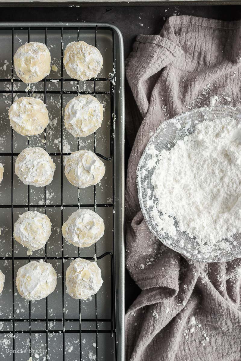 roll chocolate chip snowball cookies in powdered sugar