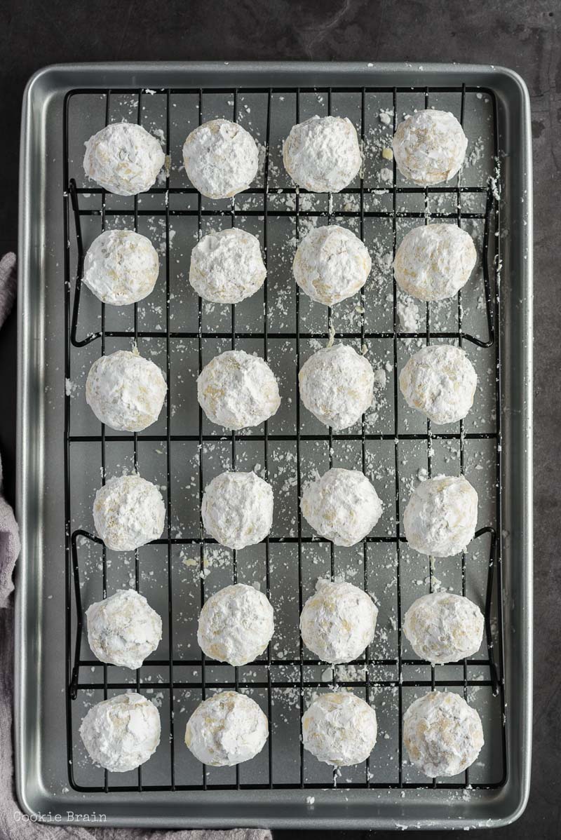 powdered sugar covered chocolate chip snowball cookies on baking rack