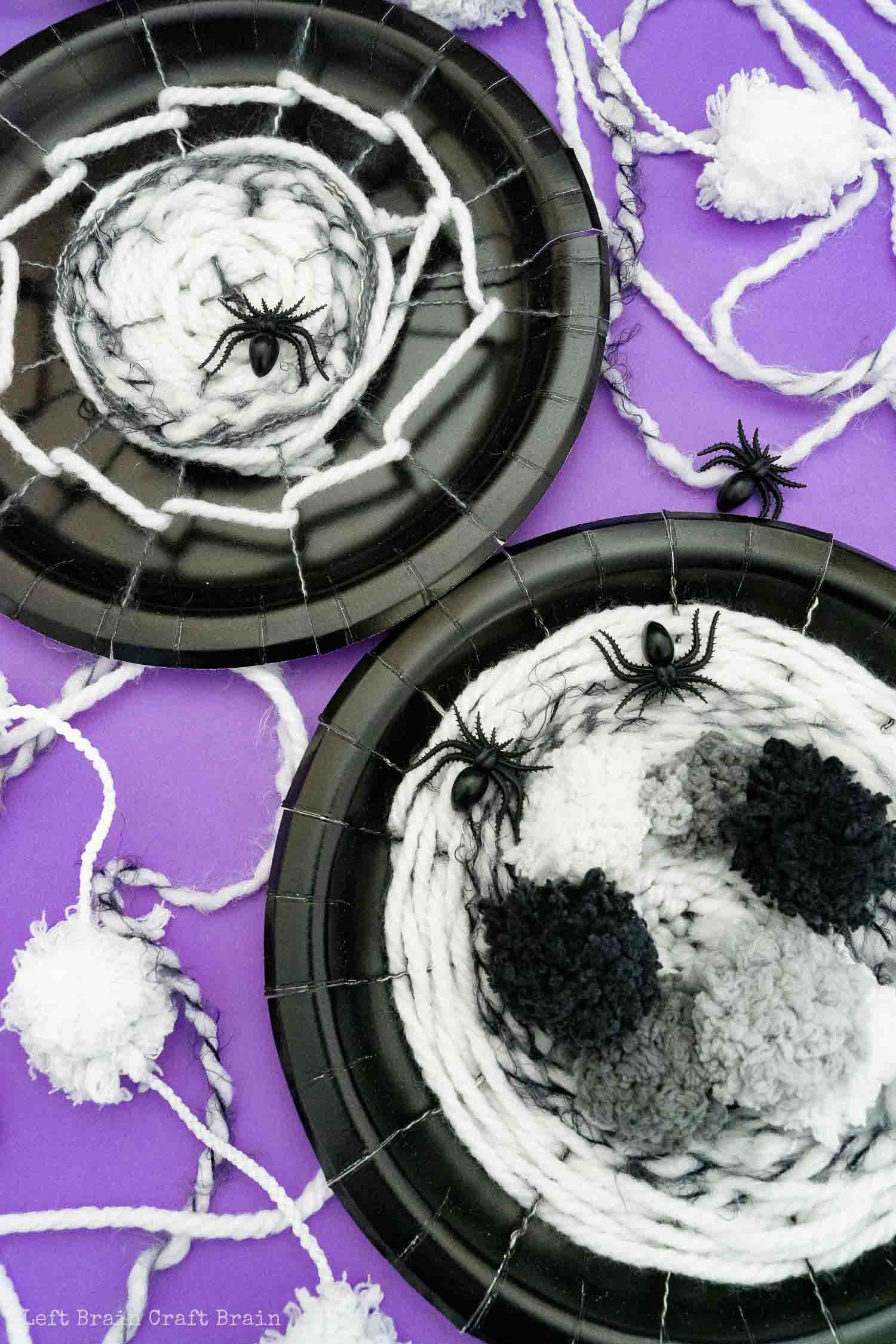 two different spider web weaving paper plates on purple with yarn and plastic spiders